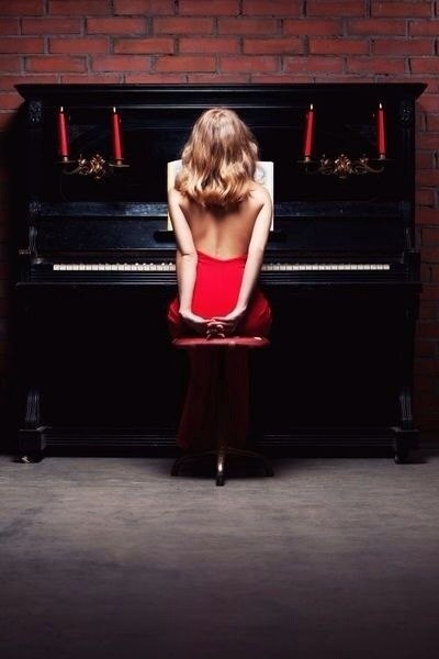 Загорелая сексуальная пианистка позирует у рояля 