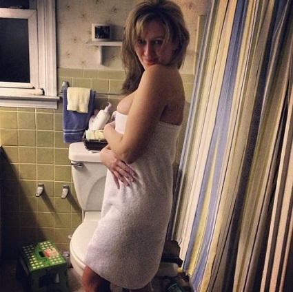 Милая блондинка снимает одежду в ванной комнате перед камерой