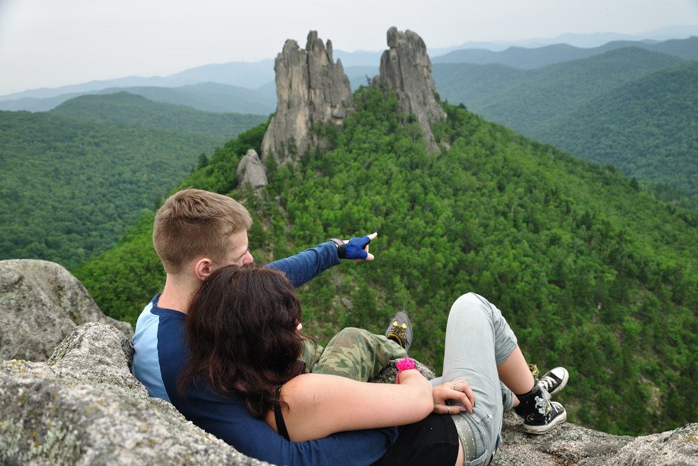Парень фотографирует голую подружку у скалы