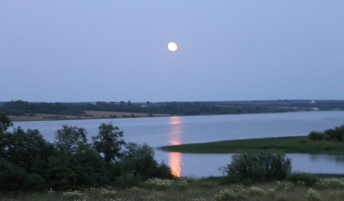 Отражение луны на воде реки дрожит