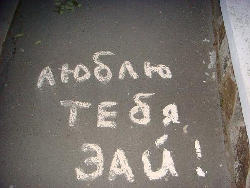 Белой краской на сером асфальте