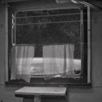 За шторами окно с решёткой