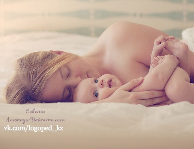 В белых пеленах кроватки спит малыш