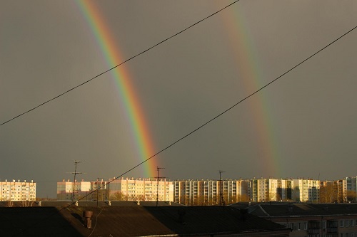 Смело двойная радуга небо проткнула серое