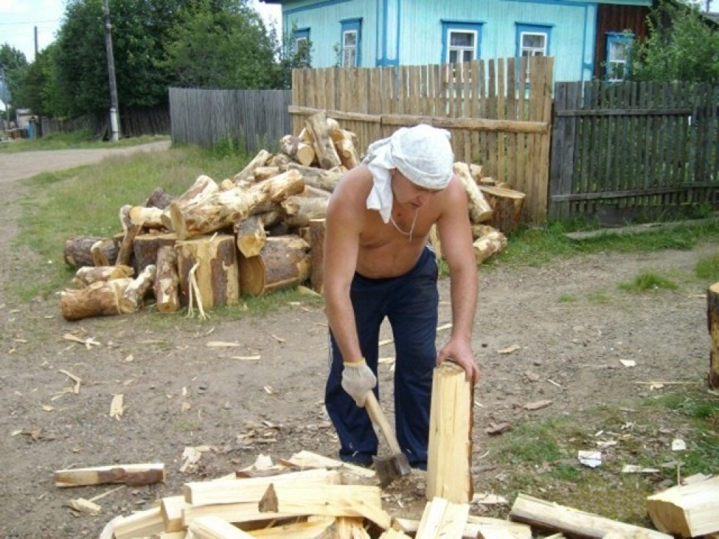 Они колят дрова. Рубка дров. Рубить дрова. Мужчина рубит дрова.