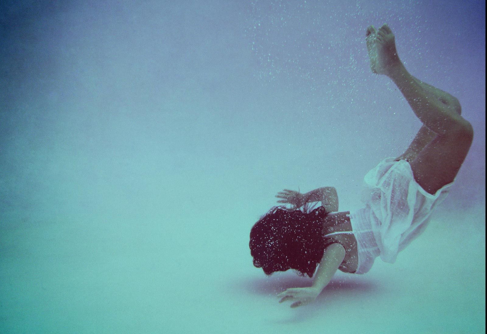 Лежать на дне бассейна. Девушка на дне. Девушка ныряет в воду. Падает на дно. Девушка на дне бассейна.