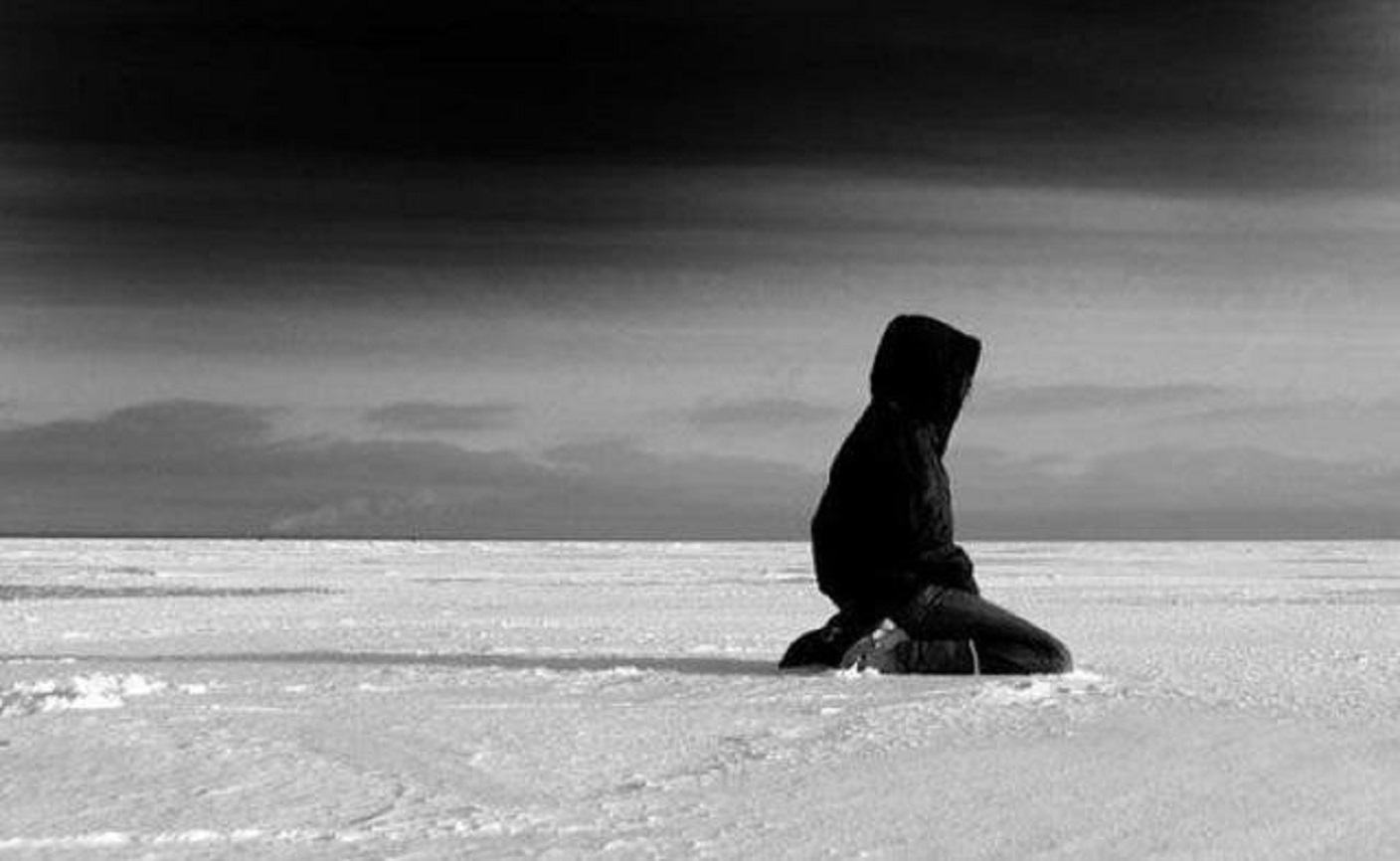 Далекий закричать. Это одиночество. Человек сидит на снегу. Зима одиночество. Одиночество мужчины.