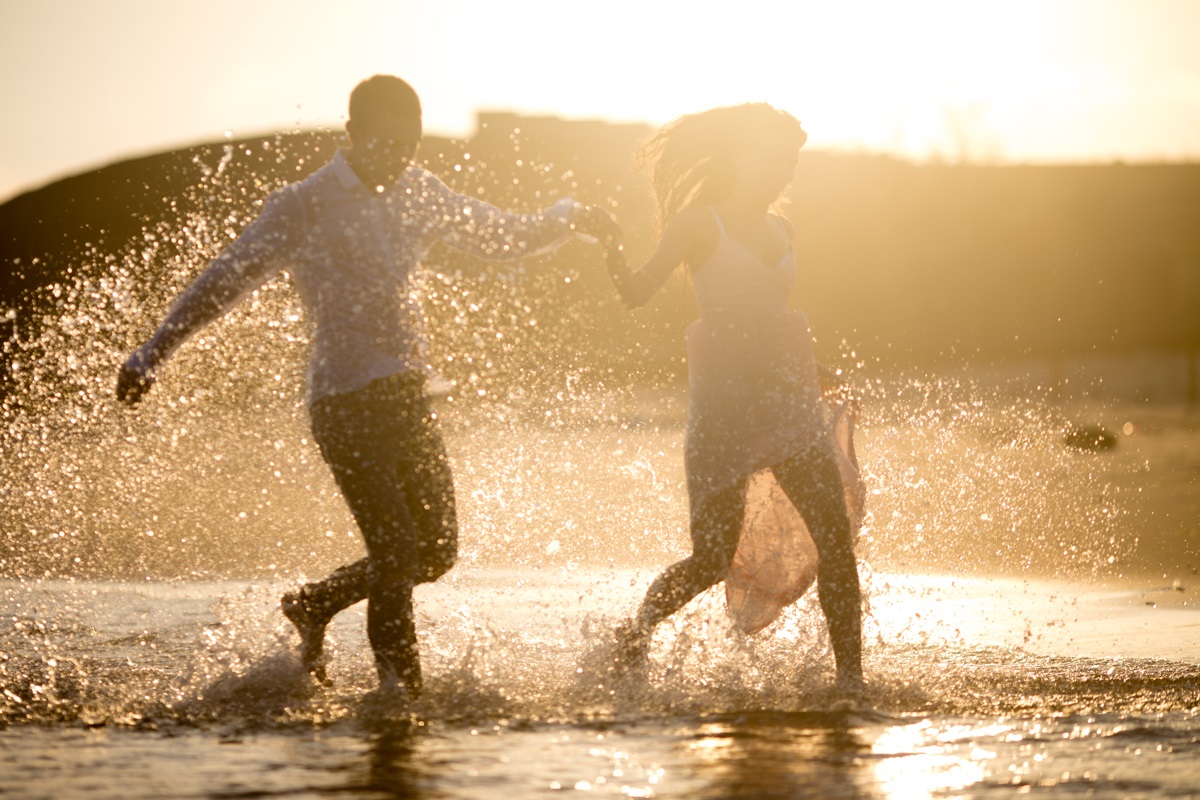 Влюбился сбегаю. Прогулка у воды. Влюбленные бегут по воде. Фотосессия с брызгами воды. Пара бежит по пляжу.
