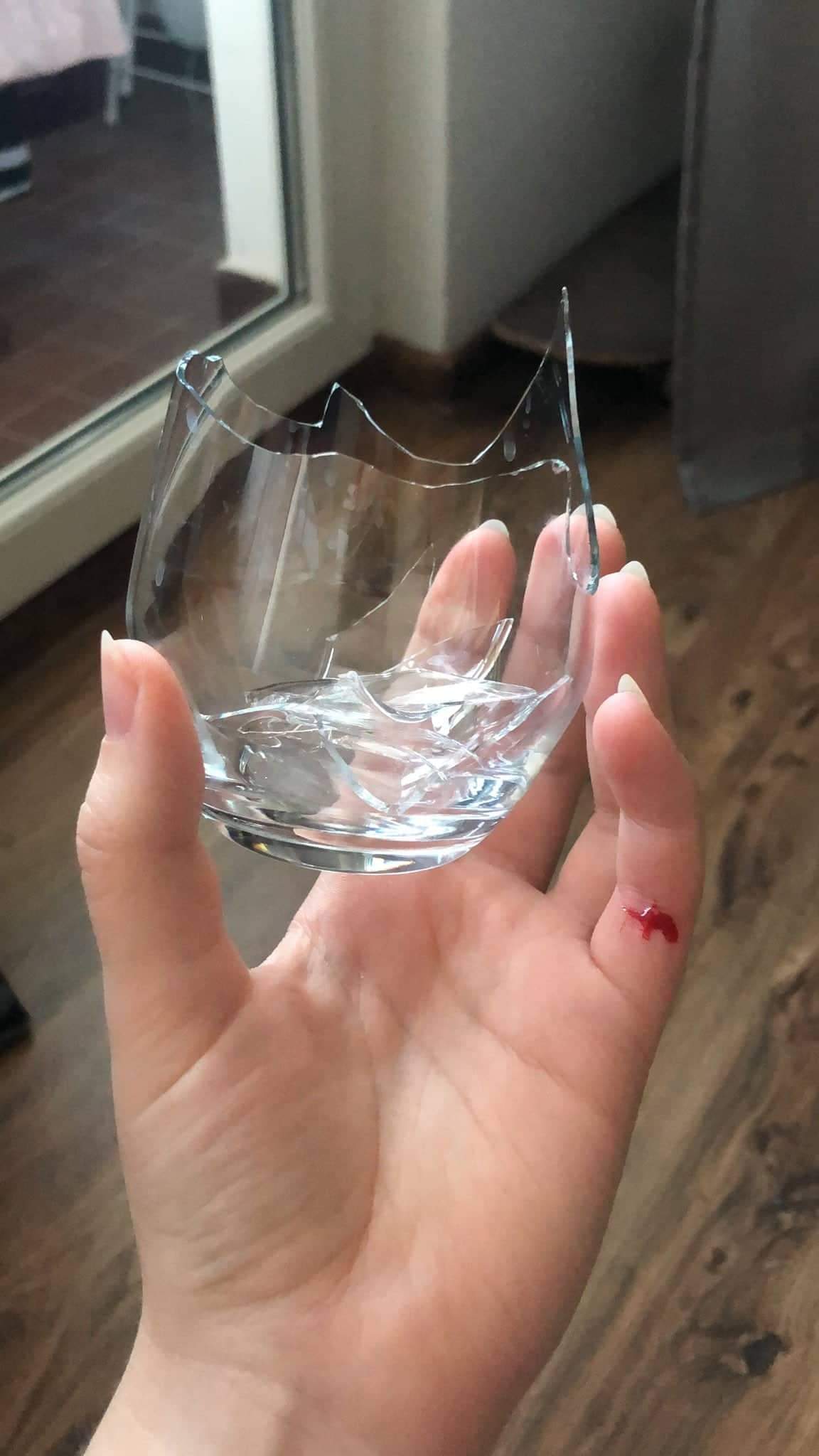 Разбилась стеклянный стакан. Рука на стекле. Разбитый стакан.