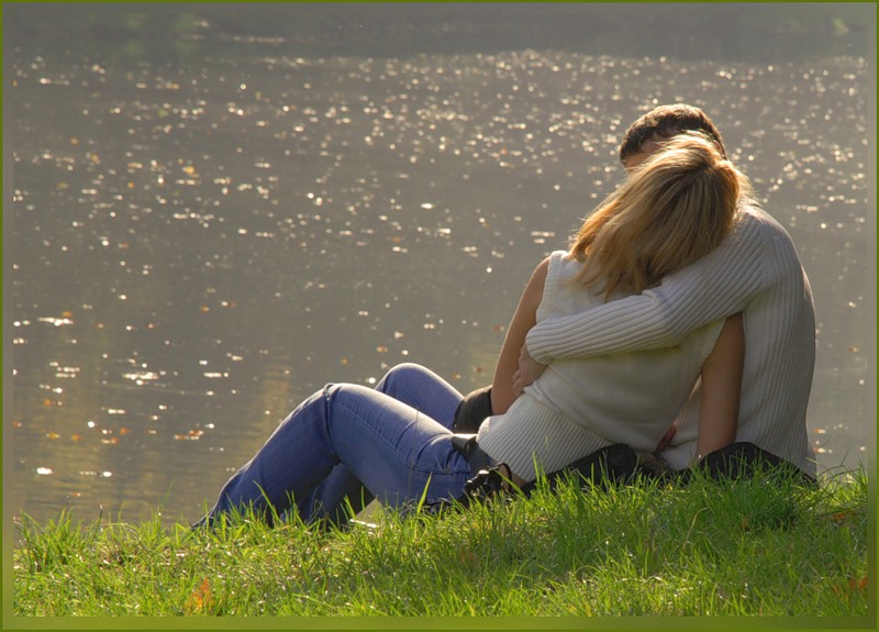 На природе с любимым человеком. Пара сидит у озера. В обнимку на берегу реки. Парень и девушка обнимаются на природе. Влюбленные у реки.