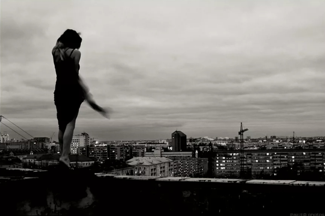 Человек стоит над городом. Девушка прыгает с крыши. Девушка хочет прыгнуть с крыши. Девушка на крыше.