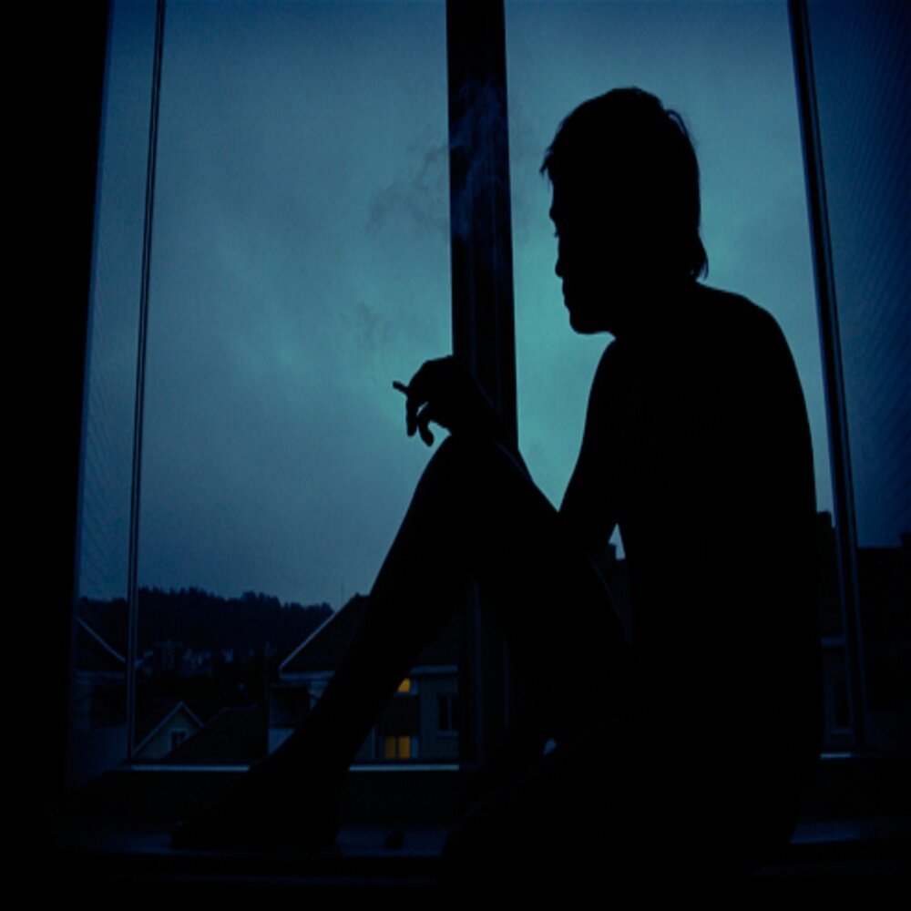Грустный мальчик в окне. Человек на подоконнике. Парень курит на балконе ночью. Парень сидит в темноте. Человек на балконе ночью.